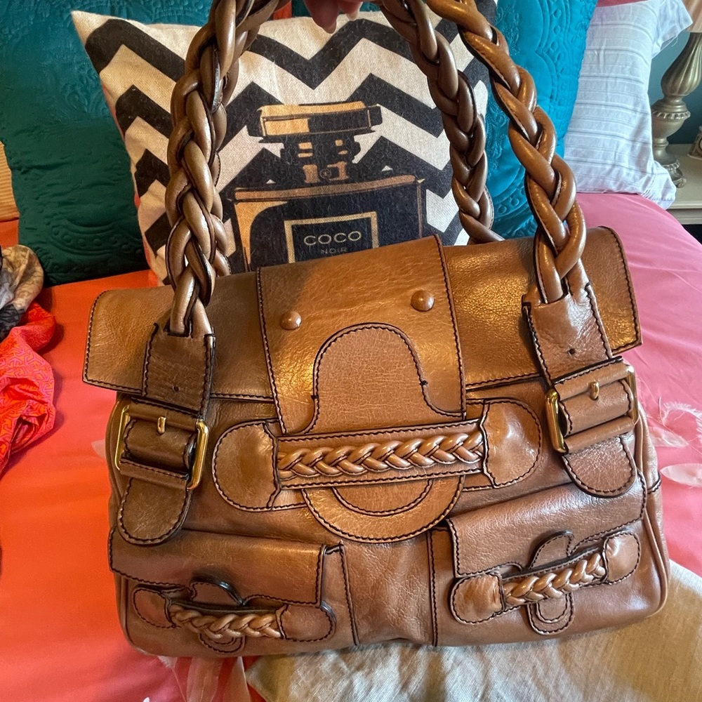 Gorgeous pearlized leather . Has lots of compartments . Beautiful statement bag!